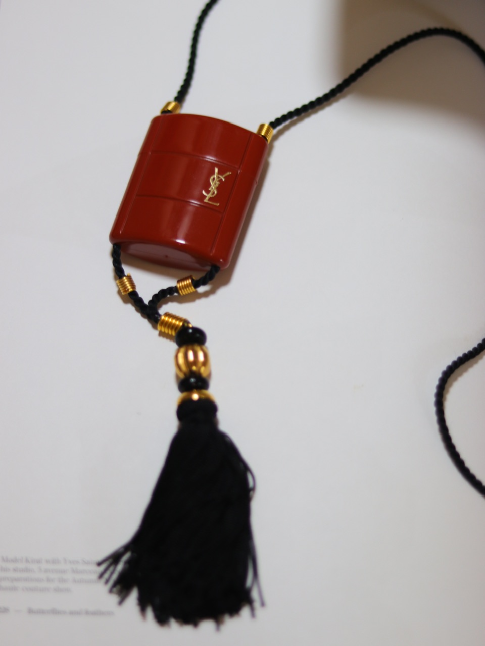 玄异亚洲风情·经典鸦片老香 朱砂红香水盒流苏项链；1970S，镀金 / 真丝绳 / 流苏 / 塑胶 / 玻璃 / 香水，项坠含流苏长约17.5厘米；项绳近24英寸（60厘米）。近乎全新，带原装盒。含满香稀有字母O玻璃瓶香水3.5毫升