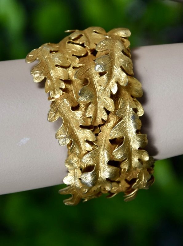 ②.橡树叶层叠DA手镯自然主义·古典雕塑气息；精美Dominique Aurientis手镯，采用磨砂与亮面金色金属制成，橡树叶层层叠合，造型生动而优雅。背面刻有签名标识。边缘处带有轻微岁月与使用痕迹。镀金；法国制造80年代DA9071