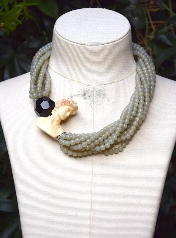 ②.古典半身像珠串绳罕见Fiocchi短项链项圈；作品呈现出当时期意大利珠宝的典型风格（其扣件设计与80年代的 Angela Caputi 相似）。项链以玉色树脂珠串联成绳状结构，一侧点缀象牙色酚醛树脂（Bakelite）古典半身像（大卫？）饰件，并搭配一枚大型黑色切面珠饰，造型鲜明而富有雕塑感。扣件内侧刻有签名；80年代F7216