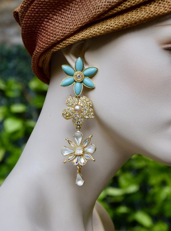 ②.春日气息花卉水晶CA扫肩长耳环；Christian Lacroix耳环，以花卉造型呈现。其一饰以珍珠心形元素（其中一枚可见轻微使用痕迹）并镶嵌水晶；另一饰则点缀磨砂水晶与极光水晶（Aurora Borealis），下方垂挂水晶坠饰。整体由绿松石色花瓣造型耳夹承托，层次丰富而华丽。背面刻有签名。镀金/人造水晶；法国制造90年代