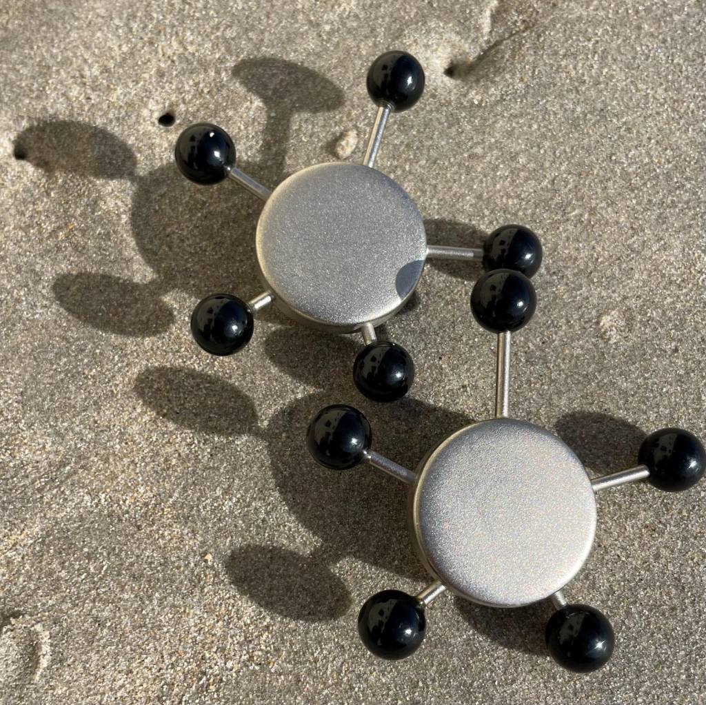 ②.“人造卫星”夹式80s耳环;前锋艺术(偏复古未来主义);哑光银色金属构成放射状结构,点缀黑色树脂球体,典型的60年代的太空时代美学。署名Victoria Studio;最大直径约6cm;金属/树脂;轻盈,成色佳;藏地法国