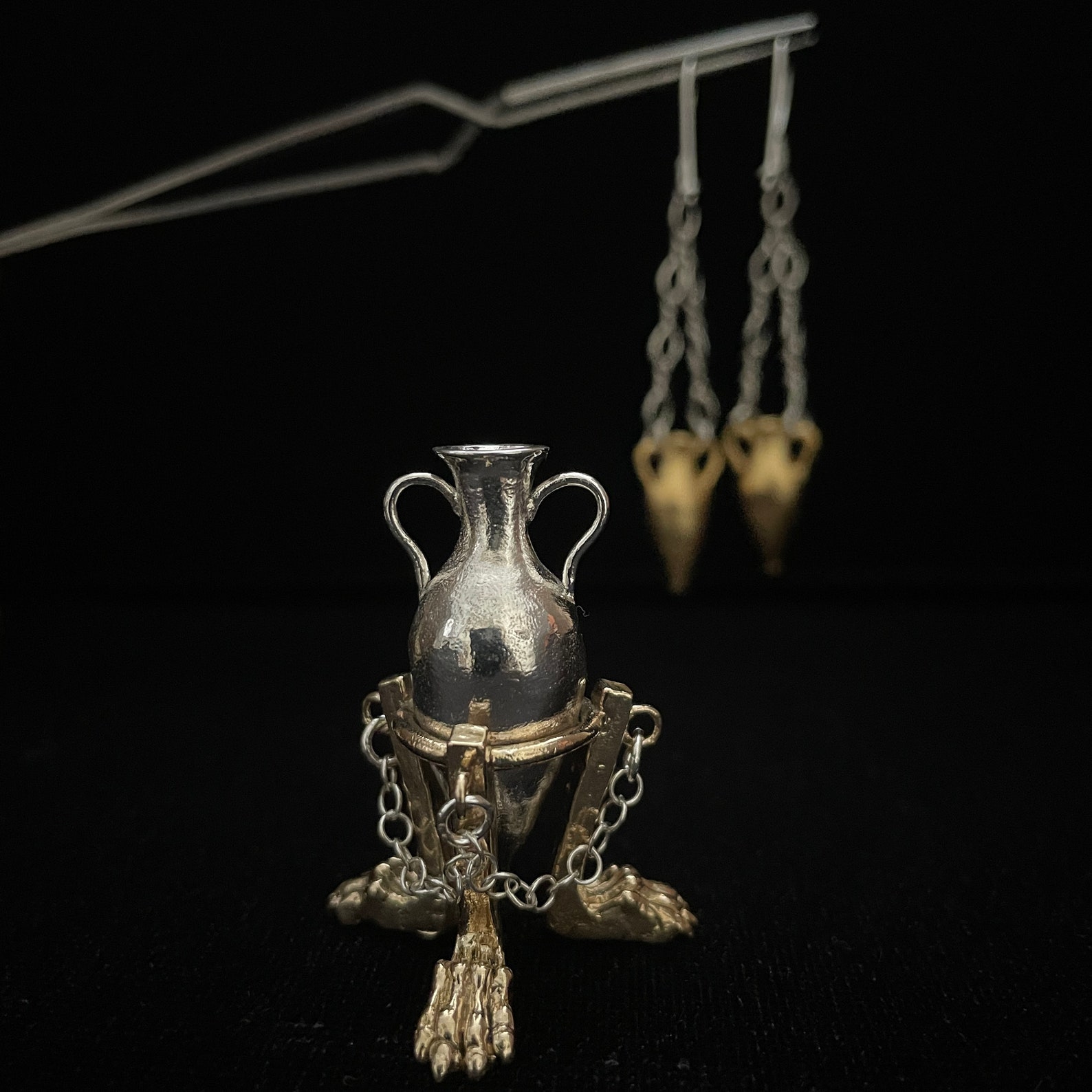 ②.三狮足承双耳瓶·”考古”系列·项坠摆件；土耳其手艺人Göksu作品；灵感源自古希腊与古罗马陶器。器身为925纯银，足部为黄铜，呈狮或狮鹫之形，赋予其守护与力量的象征。双耳瓶曾用于盛放油与酒，是古代日常与仪式的重要器物。此件将其转化为可佩戴之物，介于饰品与器物之间，既可佩戴，亦可独立陈列。925纯银+黄铜；约4cm，附纯银链（45厘米）。古老失蜡法，纯手工雕刻制作｜x4226