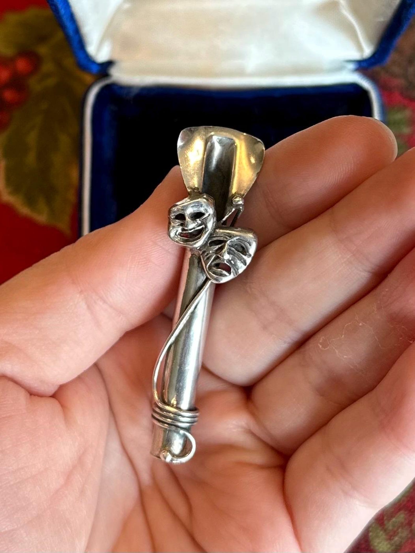 ③.悲喜面具花托胸针；以古希腊戏剧表演中的经典面具为灵感，呈现喜剧与悲剧的情绪表情。细长筒状结构，可用于插置小型花枝，使饰物在静态之外多出一层可变的自然元素。正面饰以经典的喜剧与悲剧面具，形成情绪与装饰之间的呼应。背部刻有品牌REO（60年代美国银饰老牌）与925标记；约5.6×1.5cm；美国｜x6226