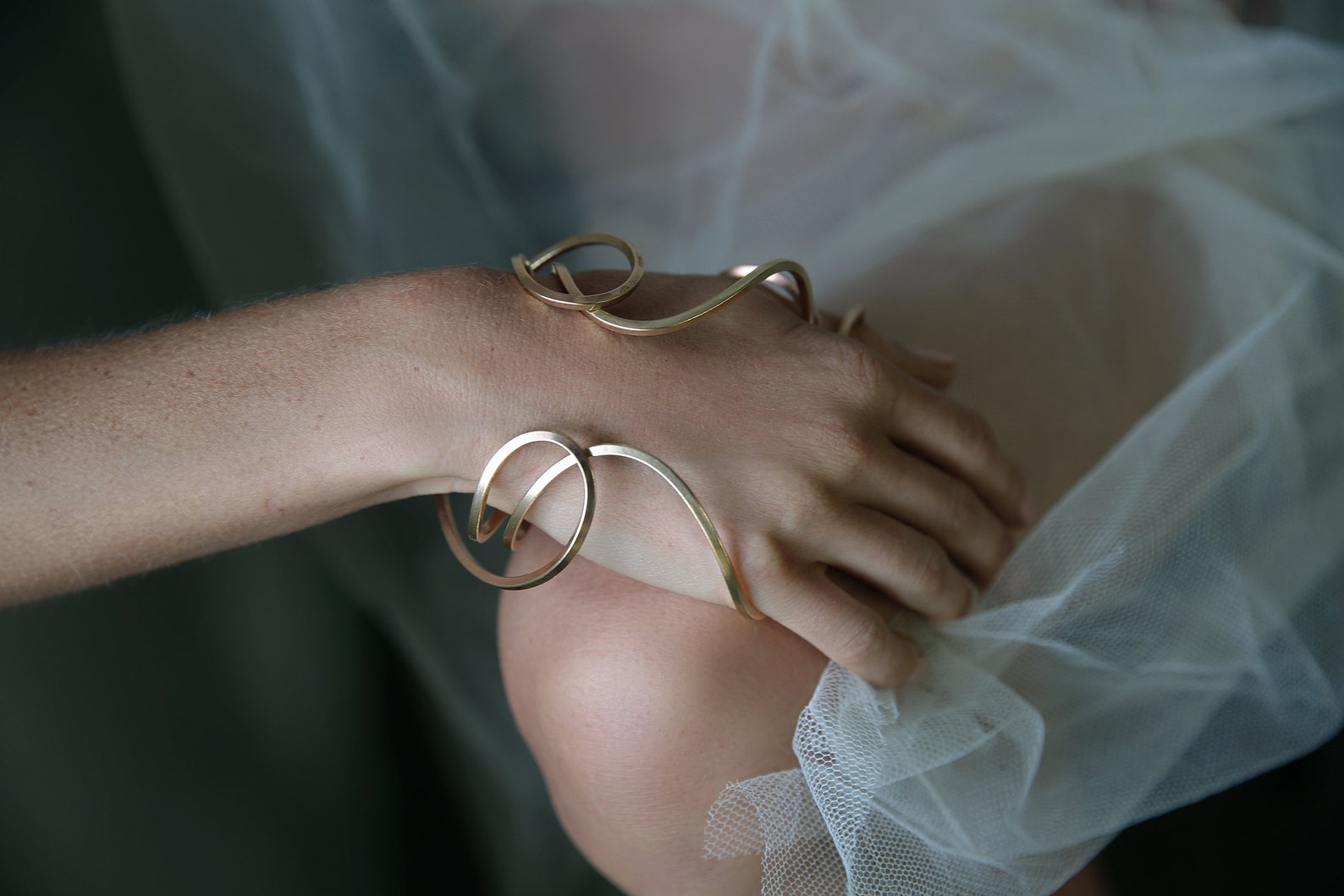 ②.大地女神瑞亚Rhea手镯·Celestial（古希腊天神）系列；英国手艺人Emma作品；以曲线为核心的开放式结构，跨越手背与手腕之间。可正反佩戴，在手腕周围形成近似“光环”的轮廓，形成一个轻微的「场域」，象征自然母神的围合与保护（承托）。均码（手环略具弹性，可微调贴合手掌），亦可定制尺码；材质有（黄铜/镀金/玫瑰金镀层/925纯银）四种可选