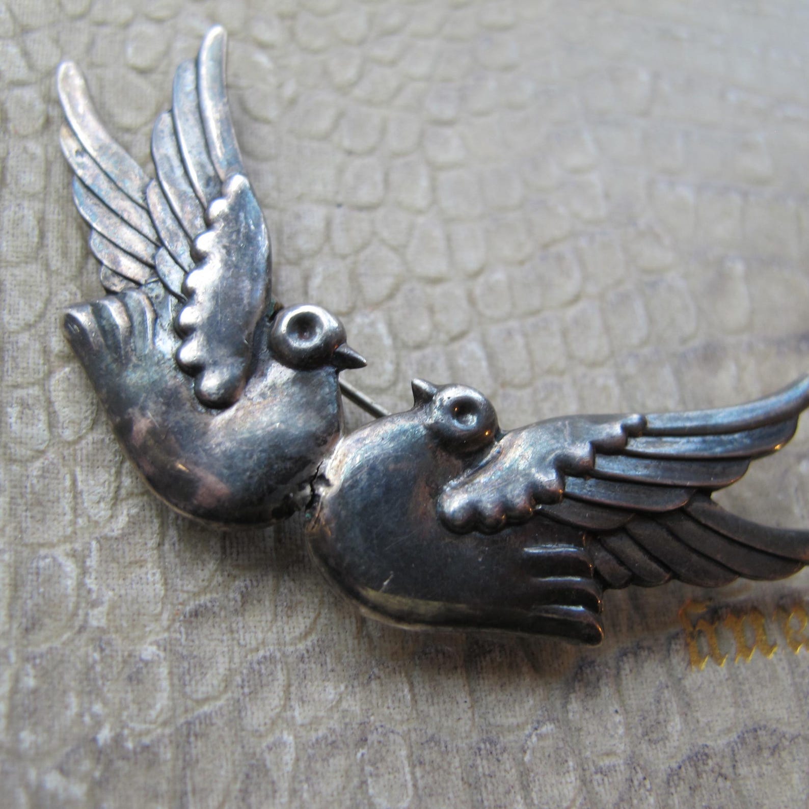②.复古爱鸟双鸟胸针；“双鸟”常被理解为爱、陪伴与连接，而“鸽子”也象征和平与温和的力量。Frida·弗里达时代气息；两只鸟相对而立，造型简练而富有情感指向，线条带有手工时代特有的质朴与力量。整体比例修长，在克制之中呈现出明确的装饰性。背部刻有Taxco 925标记（SMM / WWS）；约6.3×2.5cm；约1940–50年代，墨西哥制造｜x7326