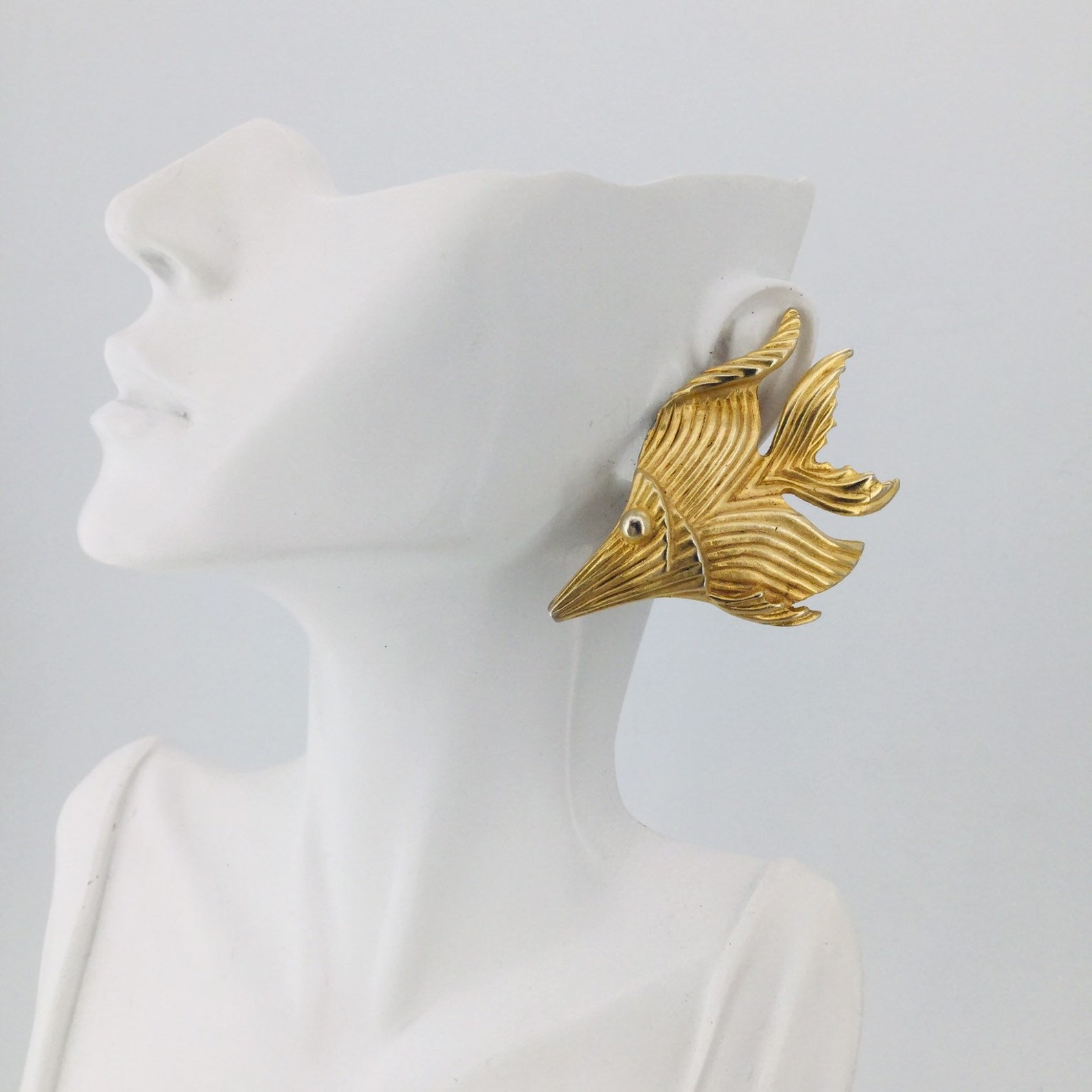 ②.热带鱼金色鱼形80s大耳环；超绝海岛夏日风情；拉丝金色表面呈现柔和光泽，两只鱼分别对应左右方向，呈迎面游动的姿态。灵动可爱，结构立体而流畅，贴合耳部。背面印有意大利品牌签名；约5.7×3.8cm；镀金；美国｜x8426