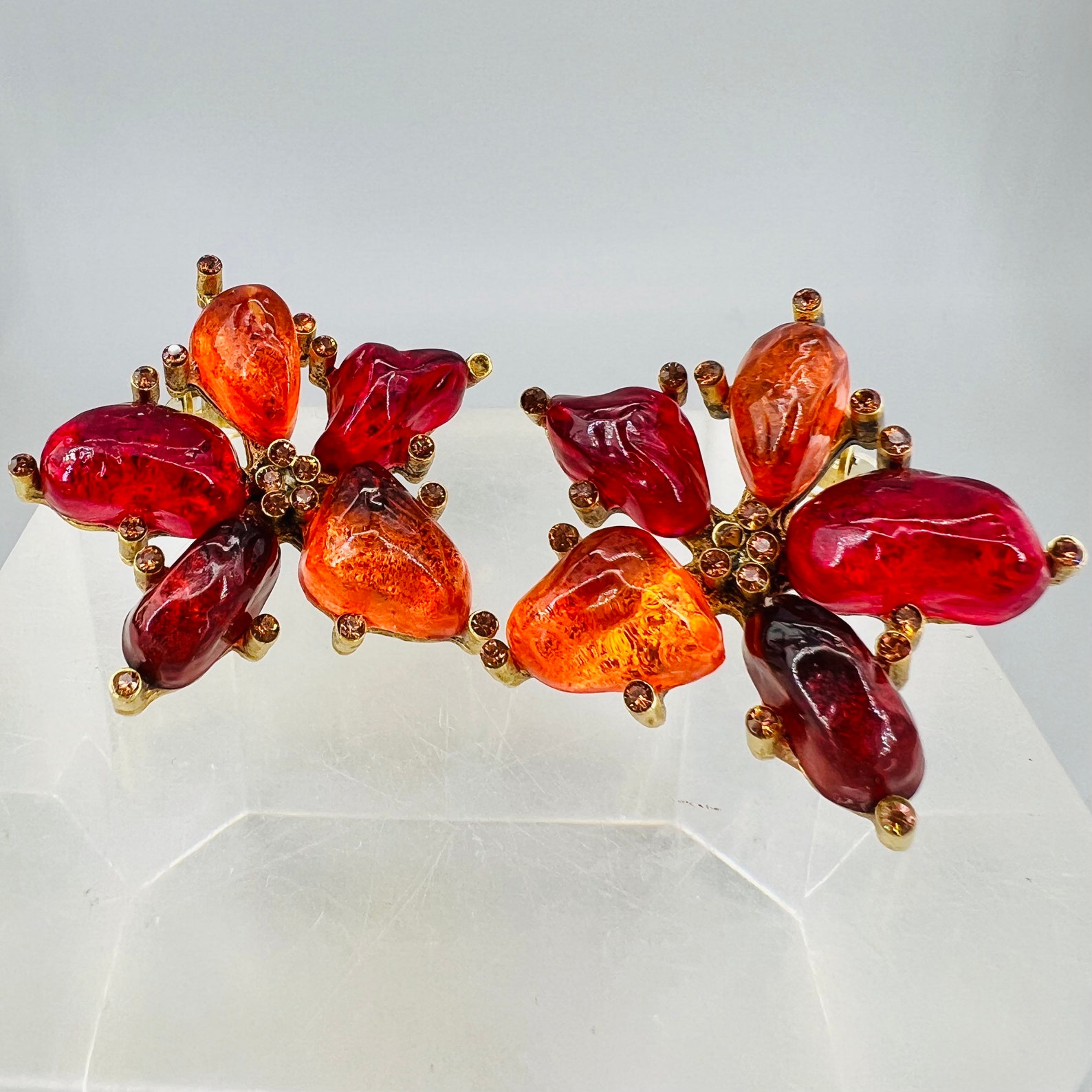 ②.火焰红橙有机花形彩宝复古80s耳环；以树脂宝石构成花瓣，呈现红与橙的层叠色调，表面带有细微凹凸质感；外围点缀橙色水钻。这类中小型金色耳饰体现当时对优雅日常佩戴首饰的追求：既有视觉亮点，凸显个性又不会过于张扬。约3.8cm，背面签名Cécile and Jeanne；镀金/浇铸树脂/人造水晶；美国｜x8326