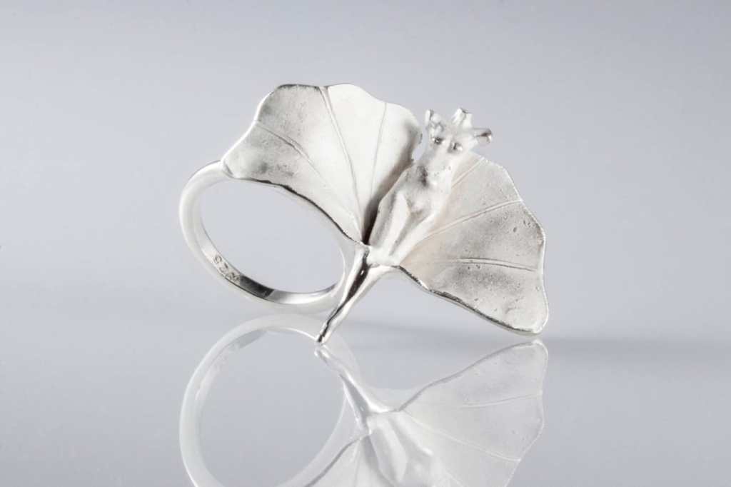 ②.「本体的喜悦」维纳斯（银杏叶）·美神系列·戒指环；美国手艺人Zbigniew作品｜有时，美之所以让人疲惫，是因为我们试图依附它、维持它、成为它。对身体的照顾——睡眠、饮食、运动，以及阅读，是为了保有一种对生活的掌控感，让自己变得稳定而清晰；而美是随之浮现的副产品。在你意识到，你可以只是经历和享受各种形相，而不被它定义，你已在它的囚笼之外。｜925纯银；雕塑约2.54cm；定制尺码；每件银的表面处理，雕塑尺寸略有不同；亦可定制尺寸。古老失蜡法，纯手工雕刻制作｜x10426